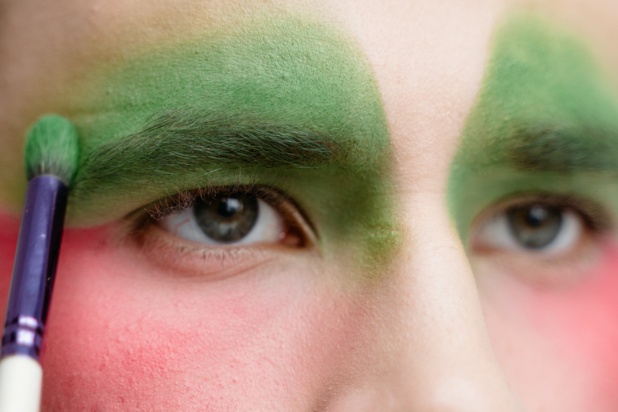 A close up shot of a person with green eyeshadow