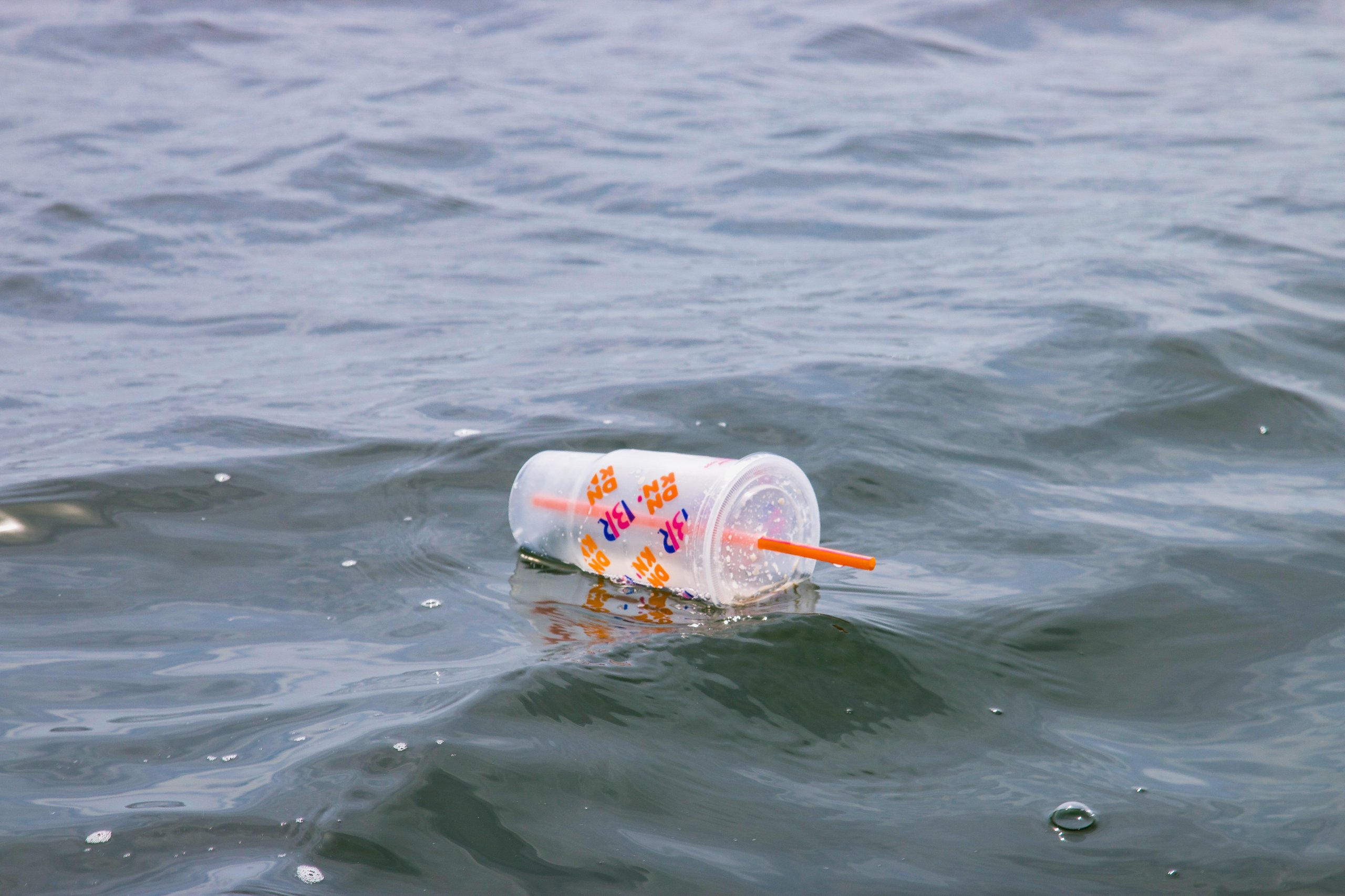 Plastic iced coffee cup with plastic straw floating in the ocean. I came across this single-use plastic while fishing out at sea. To prevent this from ever happening one action that anyone can take at home is to opt for a re-usable coffee cup. You can also become engaged with your local decision makers to push for plastic-free legislation. Learn more: https://www.wildlifebyyuri.com/plastic-pollution-photography